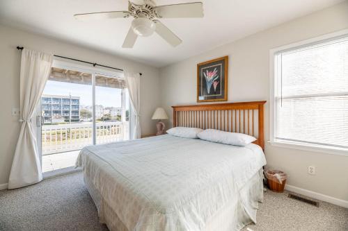 a bedroom with a bed with a ceiling fan and a window at Ocean View's in Kill Devil Hills