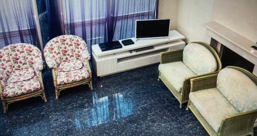 尼賴吉哈佐的住宿－Apartman De Lux，客房设有2把椅子、电视和书桌。