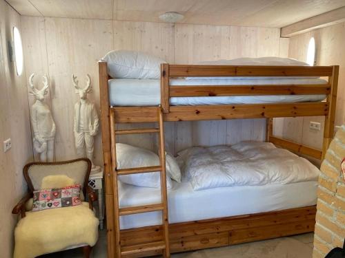 a bedroom with two bunk beds and a chair at Albliebe am Rosenbühl in Münsingen