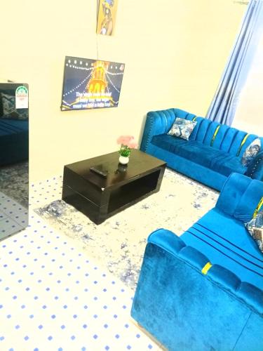 Vilma Apartment في مومباسا: غرفة معيشة مع أريكة زرقاء وطاولة