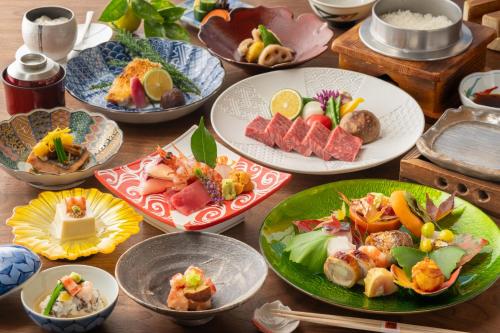 a table topped with plates of food on plates at Ryoso Yufuin Yamadaya in Yufuin