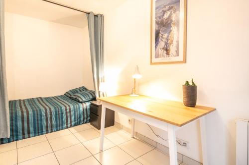 Habitación pequeña con escritorio y cama en Studio 3 Oisans - Terrasse et parking privé, en Meylan