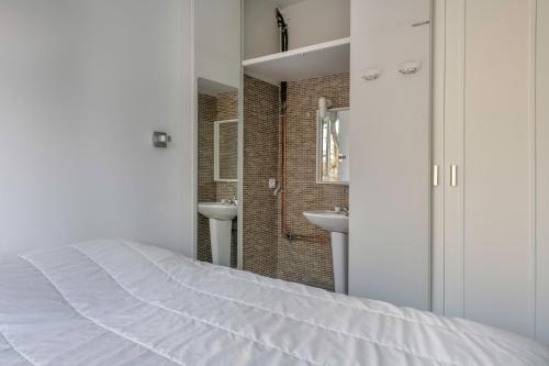 - une chambre blanche avec un lit et une salle de bains dans l'établissement Parenthese familiale tout pres de la plage, à Pornichet