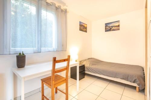 1 dormitorio con escritorio, 1 cama y ventana en Studio 4 Vercors - Terrasse et parking Privé, en Meylan
