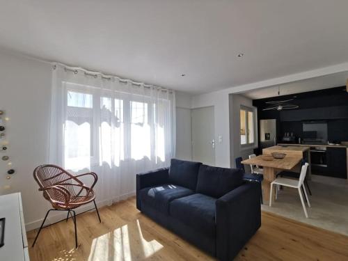 un salon avec un canapé bleu et une table dans l'établissement Dark blue Appartement 2 chambres climatisation parking 900m des remparts, à Avignon