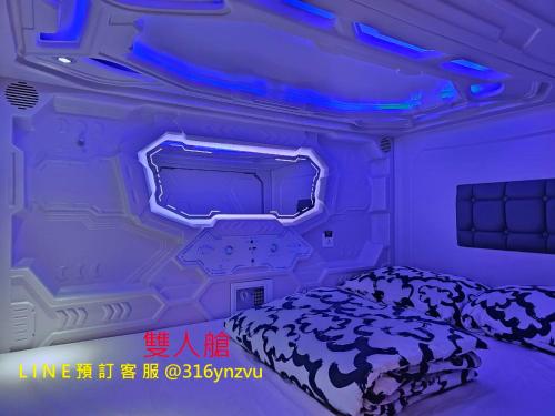 a room with a bed and a blue light at 天河行旅 in Luodong