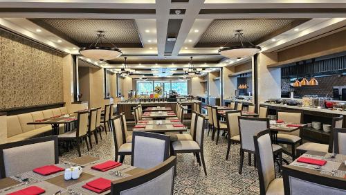 a dining room with tables and chairs in a restaurant at Swiss-Belhotel Airport Yogyakarta in Yogyakarta
