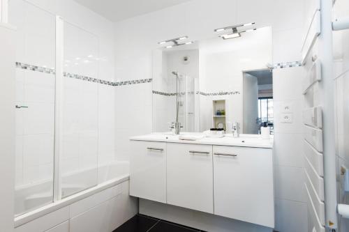 une salle de bain blanche avec deux lavabos et une douche dans l'établissement Vue mer & Tour Odéon - Terrasse - Parking - BJ, à Beausoleil