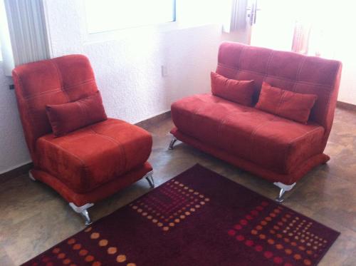 two chairs and a couch in a living room at Hotel Leyenda del Tepozteco in Tepoztlán