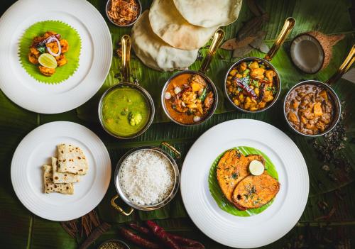 a table with white plates of food and different types of food at Gateway Coonoor - IHCL SeleQtions in Coonoor