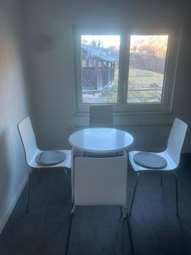 a table and two chairs in a room with two windows at Montel PARK - Nizza in Landl