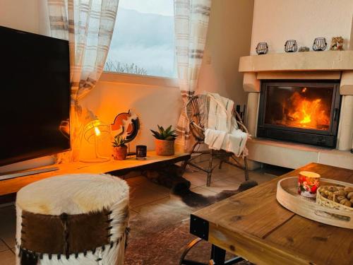 sala de estar con chimenea, mesa y TV en New Villa Montagne & Lac Cheminée 4 chambres vélos, en Saint-Jorioz