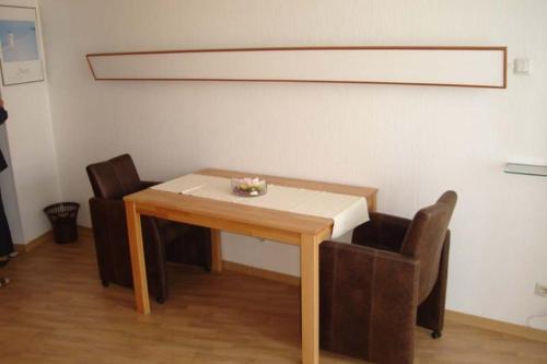 een eettafel met 2 stoelen en een tafel met bij Seehütte Ferienwohnung 306 in Cuxhaven