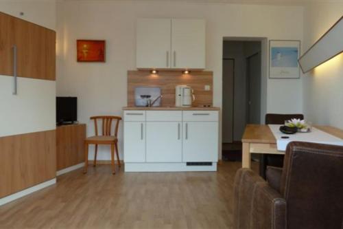 een keuken en een woonkamer met een tafel bij Seehütte Ferienwohnung 306 in Cuxhaven