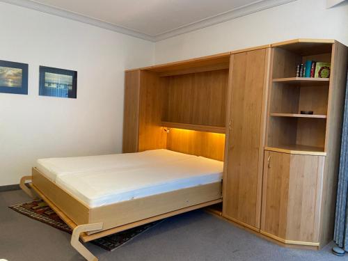- une chambre avec un lit et une armoire en bois dans l'établissement Haus Dwarslöper, Ferienwohnung 2, à Cuxhaven