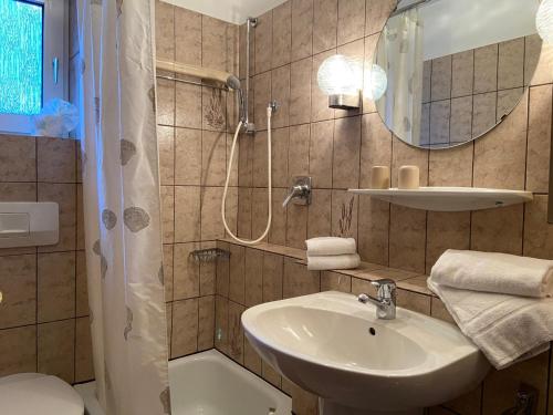 La salle de bains est pourvue d'un lavabo et d'une douche. dans l'établissement Haus Dwarslöper, Ferienwohnung 2, à Cuxhaven