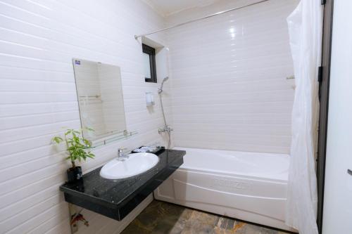 La salle de bains est pourvue d'un lavabo et d'une baignoire. dans l'établissement Thác Bà Paradise Islands - TRANG CHÍNH THỨC, à Yen Bai