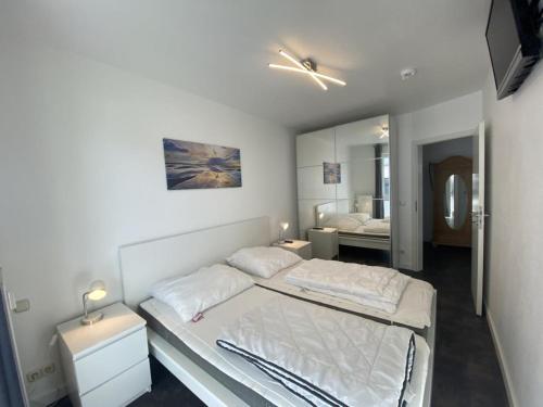 a bedroom with two beds and a mirror at Villa Döser Strand in Cuxhaven