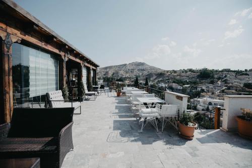 a balcony with tables and chairs on a building at Artium Cave Hotel in Mustafapaşa