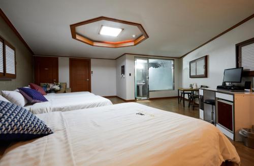 a hotel room with two beds and a television at Buantreehotel Blackhouse in Buan