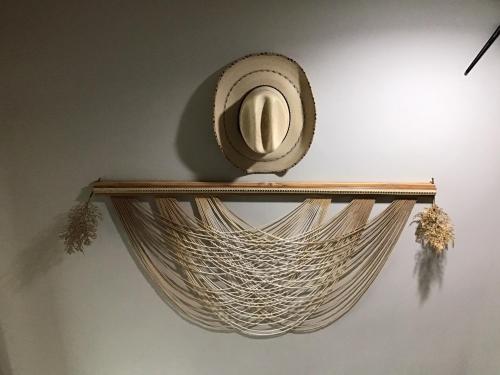 a rattan shelf with a hat on a wall at Turtle Nest in Khao Tao