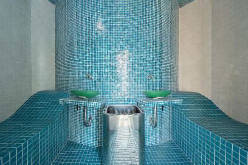 a blue tiled bathroom with two sinks and a trash can at Sunbreeze Delux Vilas in Budva