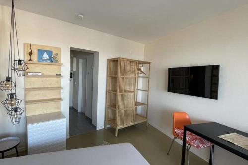 Zimmer mit einem Schreibtisch, einem TV und einem Tisch in der Unterkunft Seehütte Ferienwohnung 507 in Cuxhaven