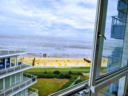 Blick auf den Strand aus dem Fenster eines Gebäudes in der Unterkunft Seehütte Ferienwohnung 507 in Cuxhaven