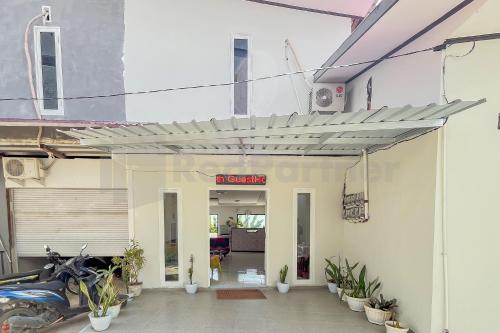 une entrée à un bâtiment avec une moto garée à l'extérieur dans l'établissement Namirah Guesthouse Redpartner, à Balikpapan
