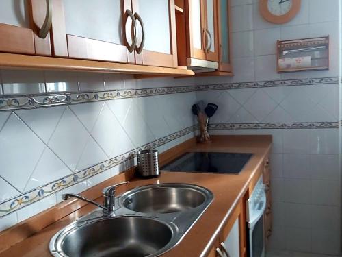 a kitchen with a stainless steel sink and wooden counters at Junto a la Calle Betis: El corazón de Triana in Seville