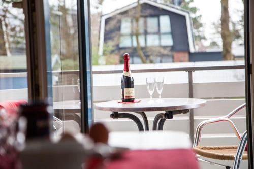 eine Flasche Wein auf einem Tisch mit zwei Gläsern in der Unterkunft Dünenglück, Ferienwohnung 13 in Cuxhaven