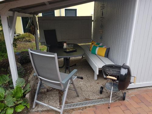 a patio with a table and a bench and a grill at Kampweg 4 in Cuxhaven