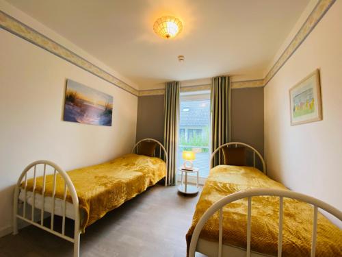 1 Schlafzimmer mit 2 Betten und einem Fenster in der Unterkunft Haus an der Düne Ferienwohnung 5 in Cuxhaven