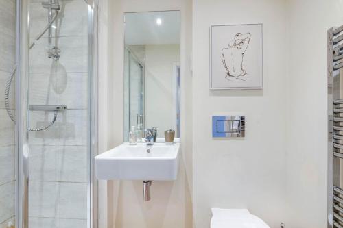 een witte badkamer met een wastafel en een douche bij Alder House Serviced Apartment Maidenhead by 360stays in Maidenhead