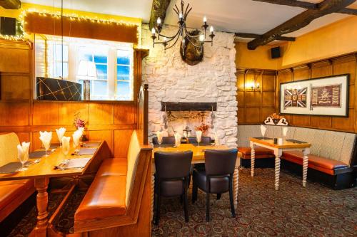 a restaurant with a table and a stone fireplace at Boars Head Hotel in Carmarthen