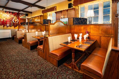 a restaurant with wooden booths and tables and chairs at Boars Head Hotel in Carmarthen