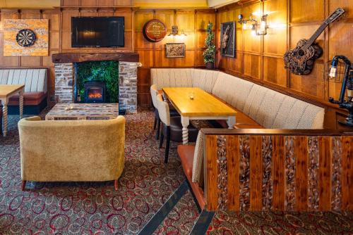 a room with a fireplace and a table and chairs at Boars Head Hotel in Carmarthen