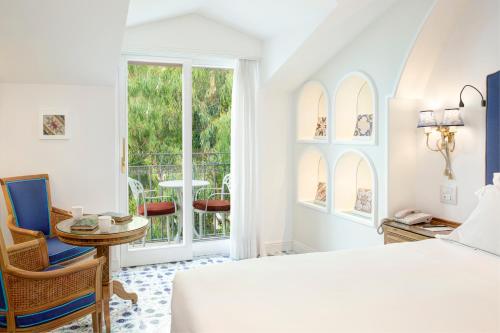 a bedroom with a bed and a table and a window at Grand Hotel Ambasciatori in Sorrento
