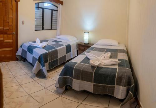 dos camas sentadas una al lado de la otra en una habitación en Hotel Los Manantiales en Panajachel