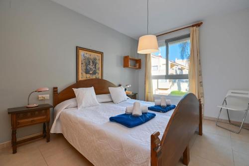 - une chambre avec un lit et des serviettes bleues dans l'établissement EvaMaria, à Jávea