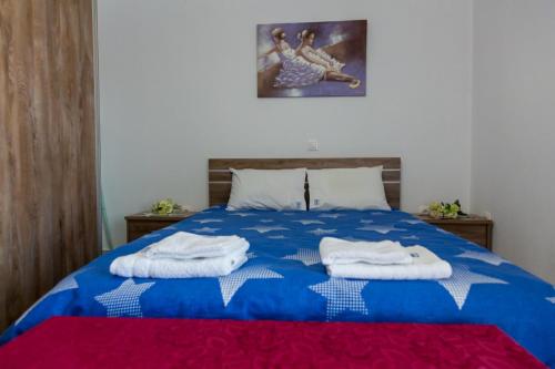 a bedroom with a blue bed with towels on it at Stavroula's Houses in Kélla