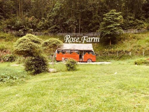 an orange bus is parked in a grass field at Eco Rose Homestay in Diện Biên Phủ