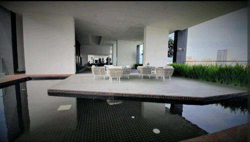 eine Terrasse mit Stühlen, einem Tisch und Wasser in der Unterkunft Urban Suite_無敵檳城大橋景Premium套房「家庭式套房」 Max8 Pax in Jelutong