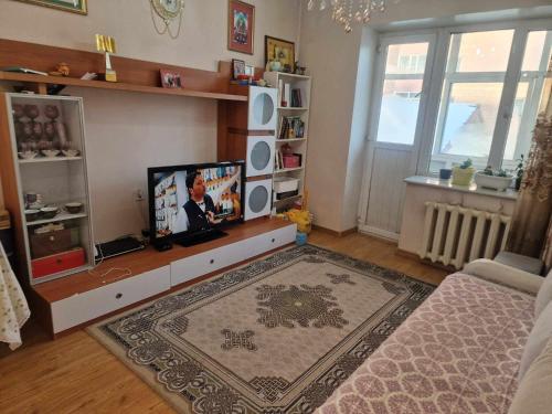 uma sala de estar com uma televisão de ecrã plano num centro de entretenimento em One bedroom apartment em Ulan Bator