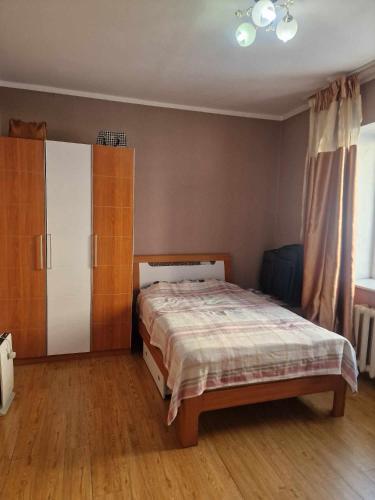 um quarto com uma cama, um armário e uma janela em One bedroom apartment em Ulan Bator