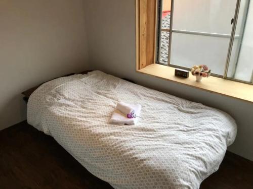 uma cama com uma almofada e uma janela em base sanablend - Vacation STAY 37414v em Kyotango