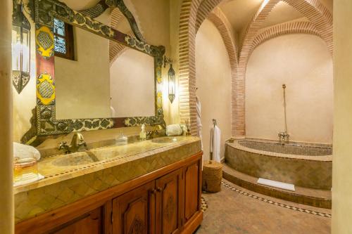 a bathroom with a large mirror and a tub at Riad Les Trois Palmiers El Bacha in Marrakech