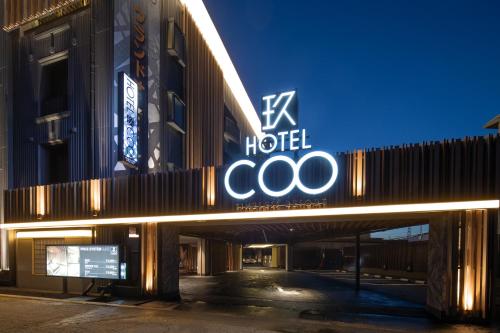 a hotel sign on the side of a building at ホテルCOO玖　男塾ホテルグループ in Okayama
