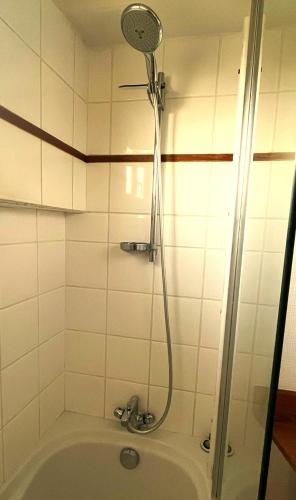 La salle de bains est pourvue d'une baignoire et d'une douche. dans l'établissement Ty Lili Roz-Appartement plage Perros-Guirec, à Perros-Guirec