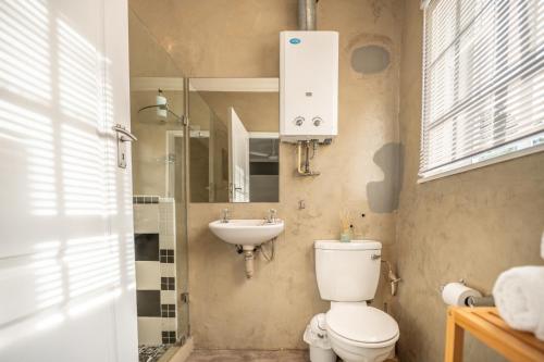 a bathroom with a toilet and a sink at A Stone's Throw Accommodation in Grahamstown
